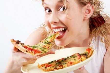 Женщина ест пиццу 